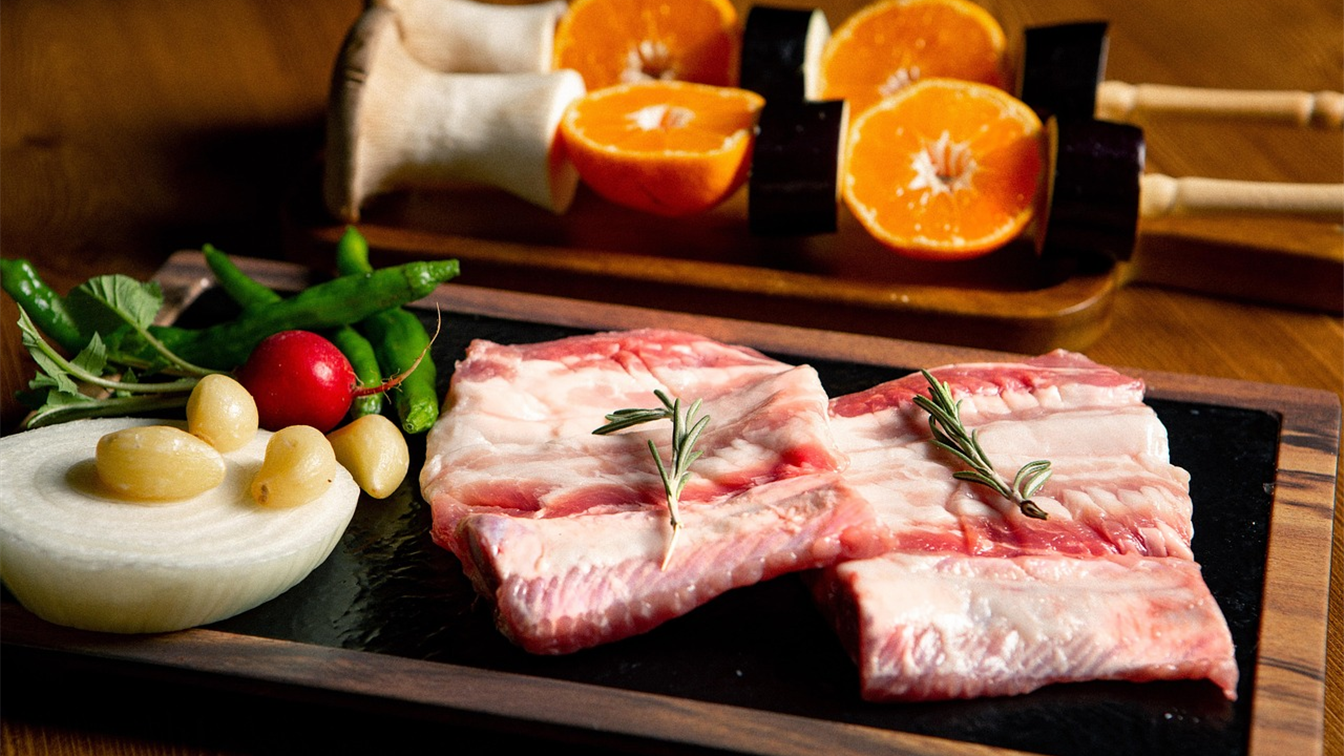 raw beef ribs seasoned on a wooden serving board