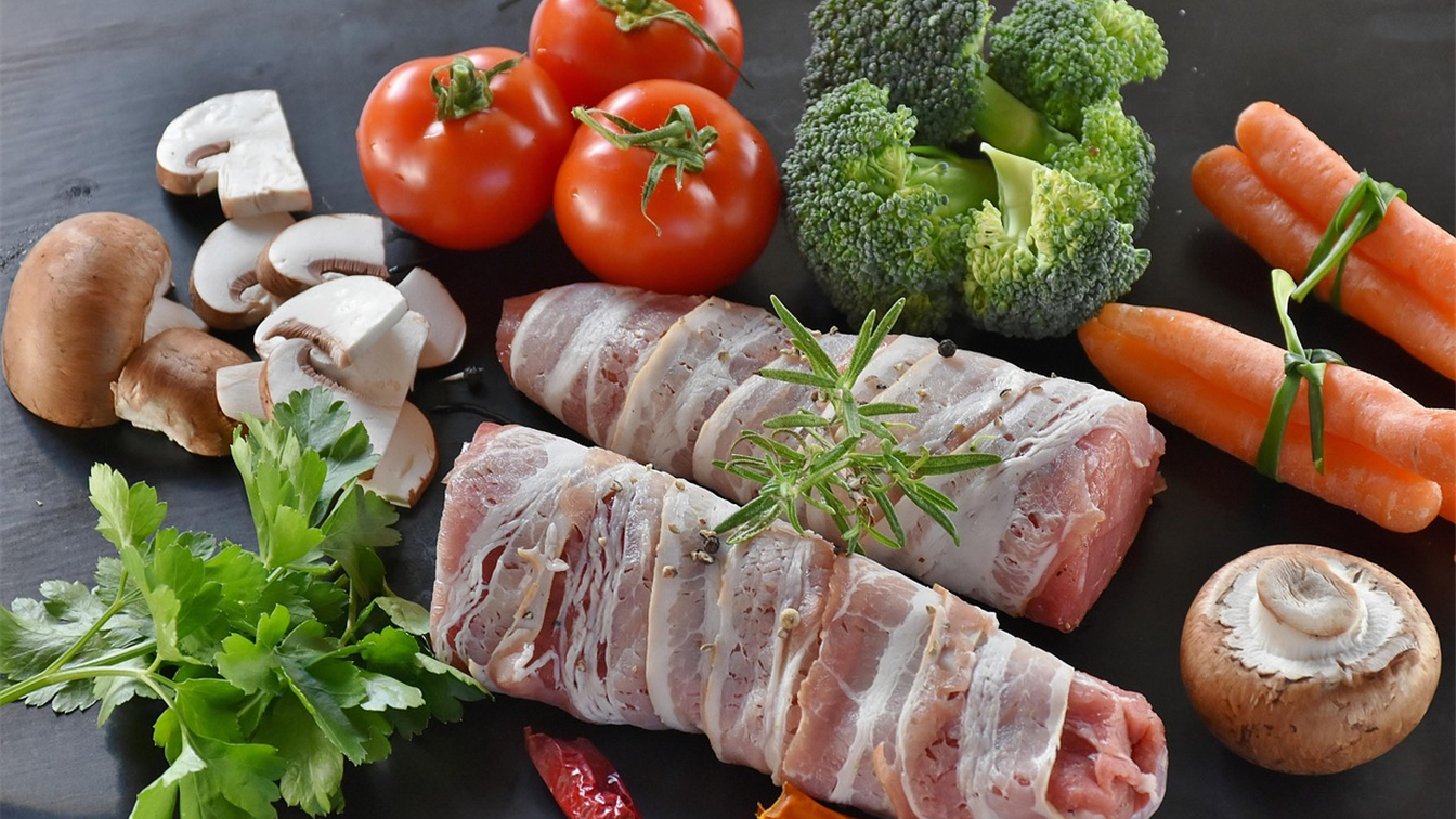 Frango e carne suina crua em tabua de madeira