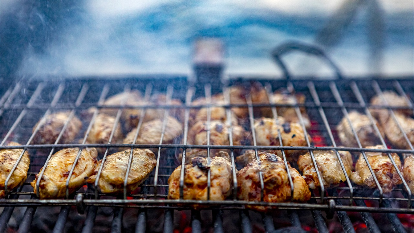 Frango na grelha de churrasco com brasas
