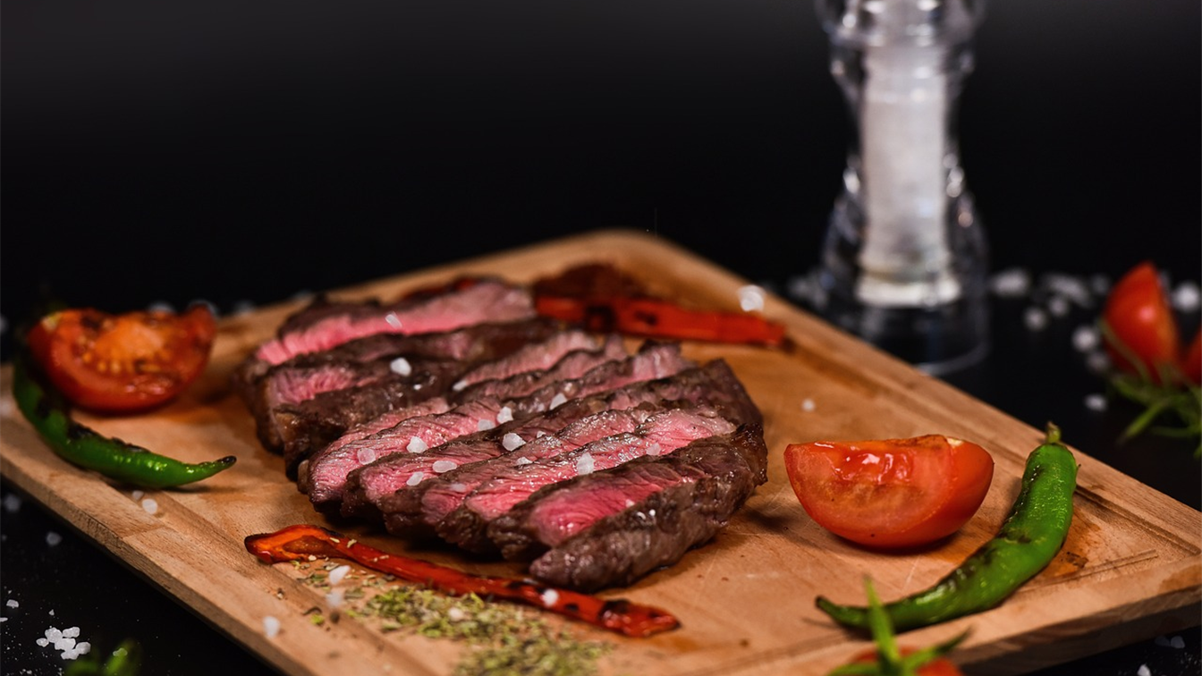 Bife fatiado na tábua com tomate e pimenta