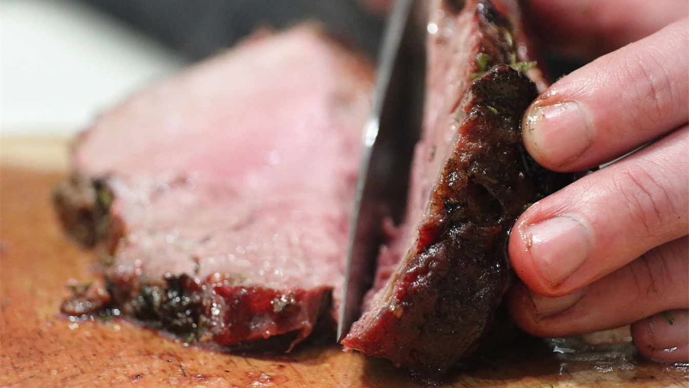 Cortes de carne defumada fatiados sobre tábua de madeira