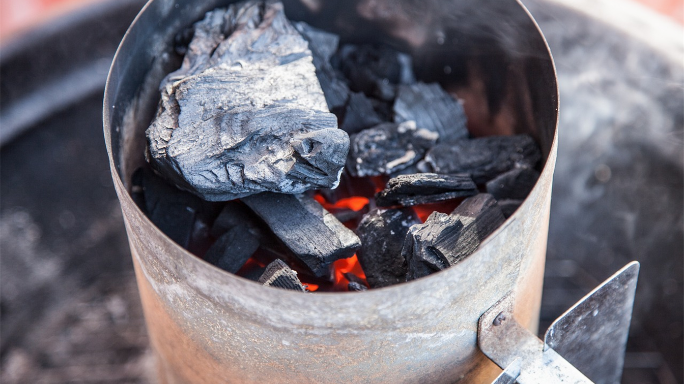charcoal glowing in a chimney starter for the barbecue